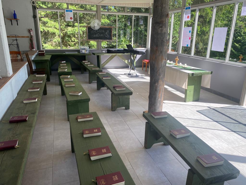 Leirikirkon penkit ja virsikirjat lasiseinäisessä paviljongissa